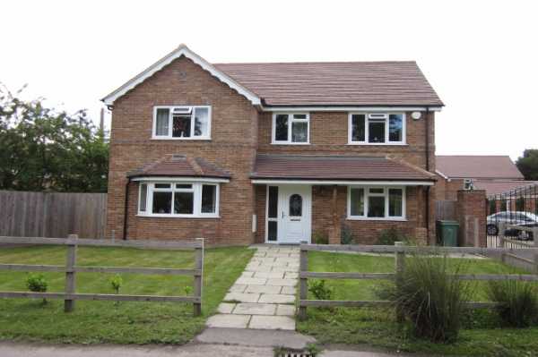Showing the front of the first property and large landscaped front garden, with long paved walkway to front door.